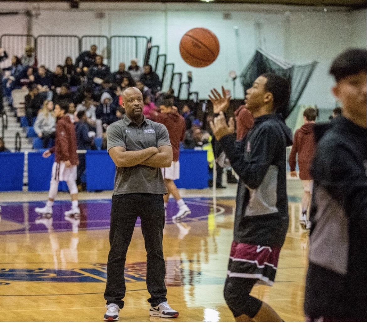Coach Leo observing players on the basketball court